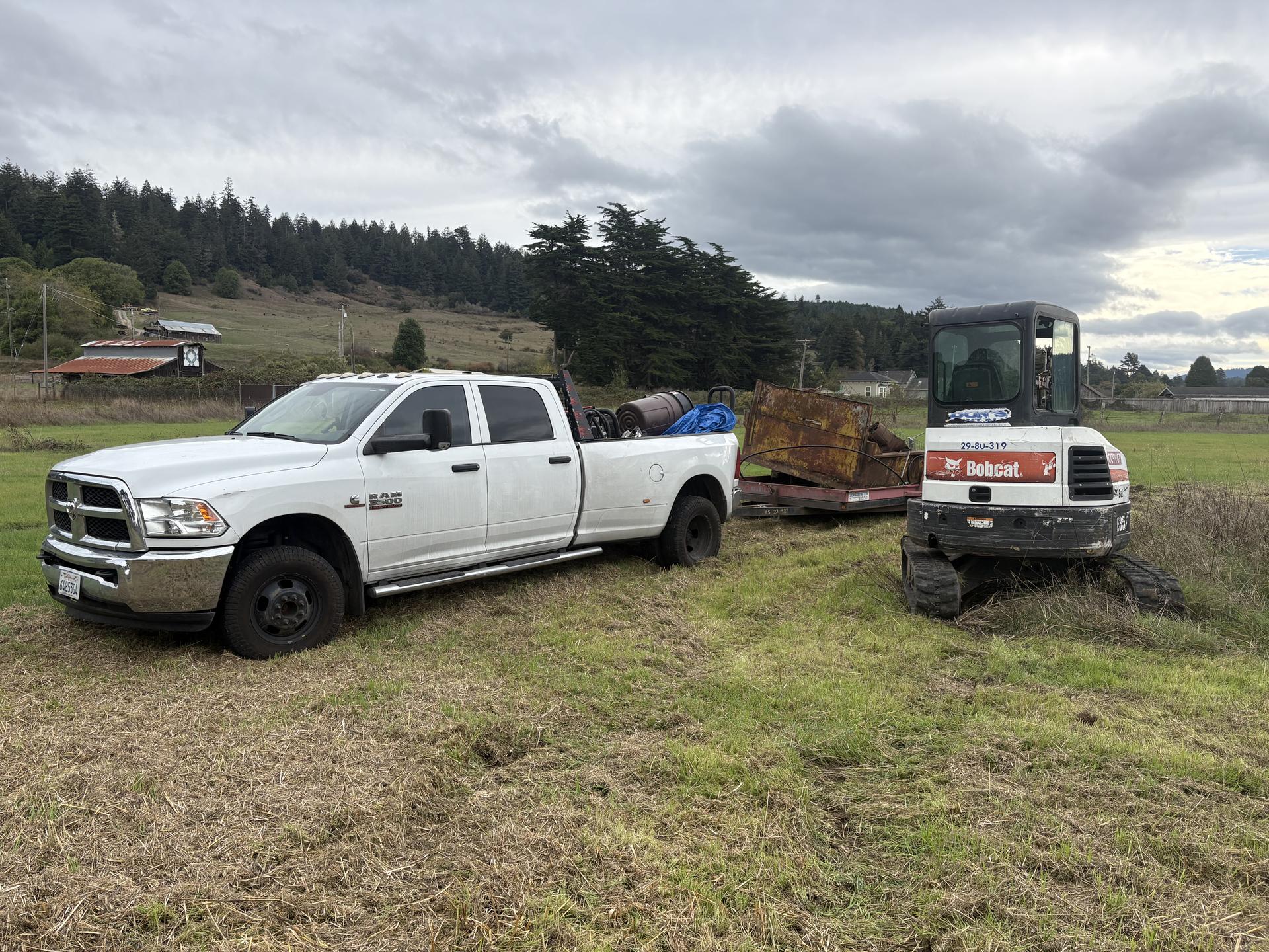 excavator clearing brush on hillside
